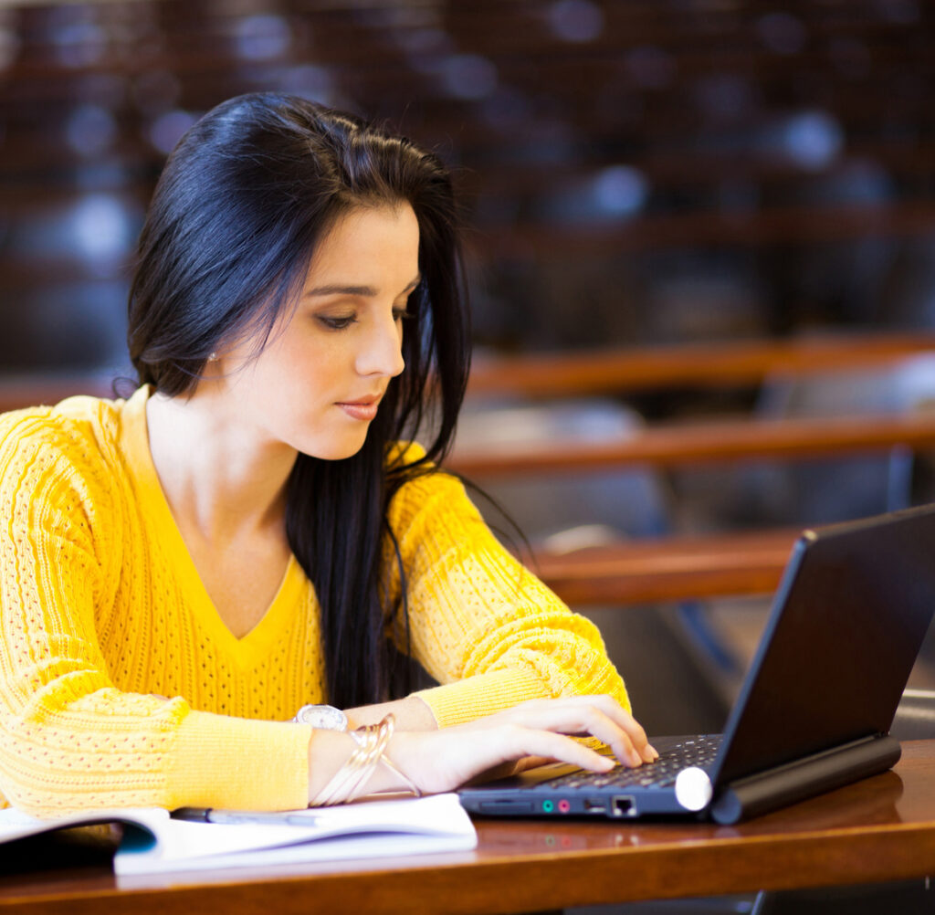 university student using laptop in classroom